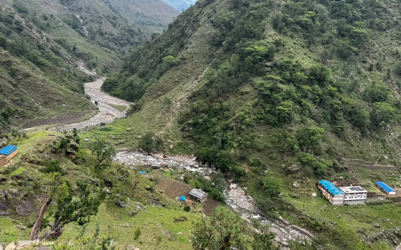 A steep river valley with a braided stream running between green mountain slopes at Middle Gad Khola